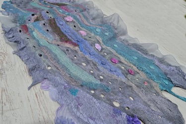 Handmade nuno felted scarf with blue and purple wool ripples, silk ruffles, and decorative holes.