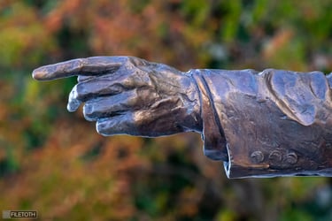 Close-up of George H. W. Bush statue’s outstretched hand, symbolizing diplomatic guidance.