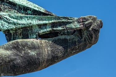 Statue’s left hand gripping the billowing flag.