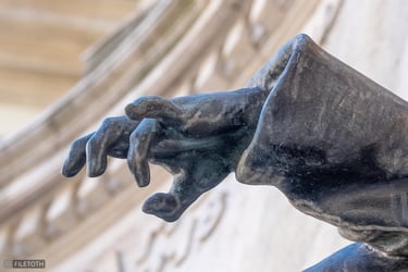 Wounded soldier’s bronze hand from the ELTE heroic memorial, fingers slack.