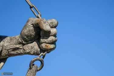 Close-up of Imre Soós’s bronze hand, thrust forward as if breaking free from a grip.