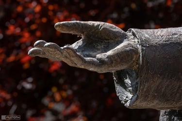 Close-up of Mindszenty’s right hand in a blessing gesture, red leaves in the background.