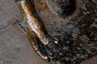 Close-up of Ernő Nemecsek’s hands throwing a marble.