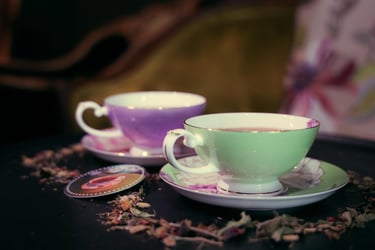 Two tea cups, one green, one purple, containing tea, the image links to Wicked Wolf daytime tea menu