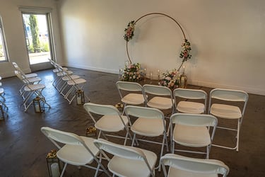 a wedding ceremony with white chairs and white chairs