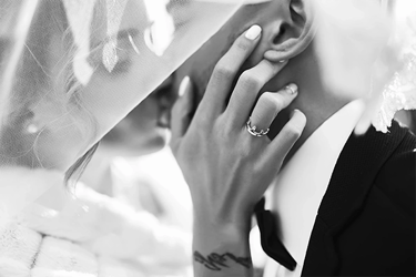 a bride and groom share a kiss under a veil