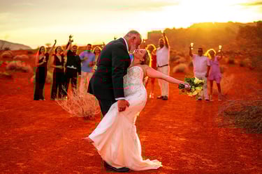 a bride and groom kissing in the desert