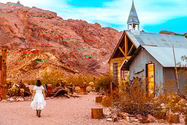 a woman in a white dress walking down a dirt road