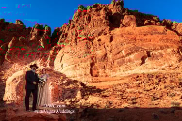 a bride and groom standing on a rocky cliff