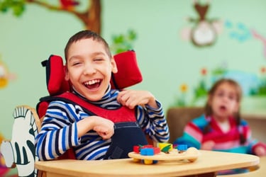 A cheerful boy with special needs smiling while playing with colorful wooden toys in a classroom.