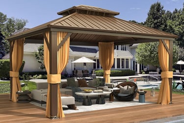 Modern hardtop gazebo with yellow privacy curtains and patio furniture on a poolside deck.