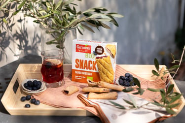 Snack Germinal Bio farro mirtillo ambientato con mirtilli freschi e bevanda