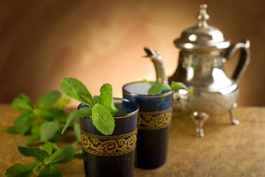 Théière avec verres à thé et brins de menthe dans le rituel traditionnel marocain