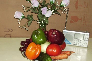 一盘水果，一个花瓶，和一个收音机。