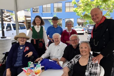 8 telelaget members sit outside under an awning