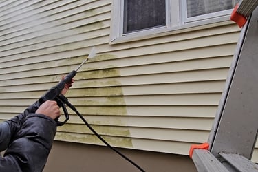 a man is powerwashing the exterior of a home