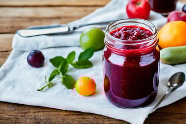 a jar of fruit juice with a spoon and spoon