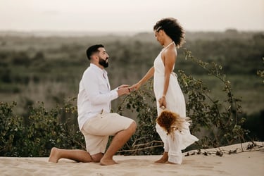 Novio se arrodilla y le pide matrimonio a su novia en la playa.