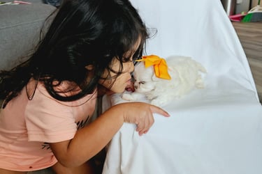 Little girl giving puppy loving kisses
