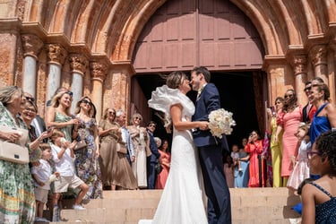 a bride and groom kissing in front of a church
