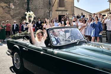 "Bride leaving the ceremony in a Provence vineyard, smiling as guests throw petals