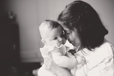 portrait en noir et blanc d’une maman tenant son bébé, moment doux et intime