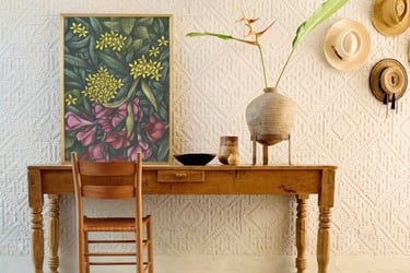 Rustic home interior with a wooden table and a chair and a botanical hand-drawn framed art print