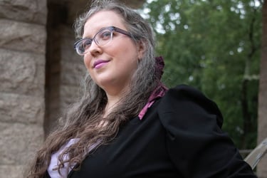Portrait of a woman in a business suit with a violet hairbow