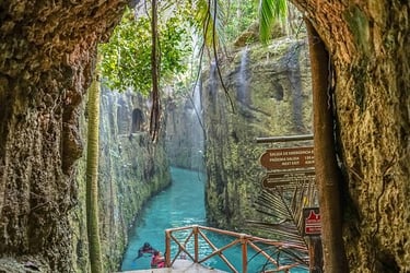 Nadadores en un río subterráneo de color turquesa  en Xcaret México