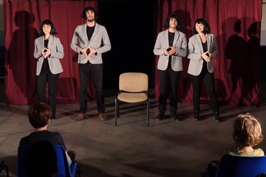 4 personanges en veste grise et perruque brune sont côte à côte théâtre forum discrimination