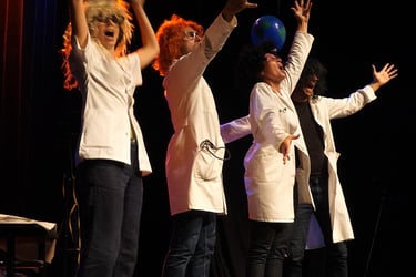 4 personnages en blouse blanche lèvenet les bras théâtre forum développement durable