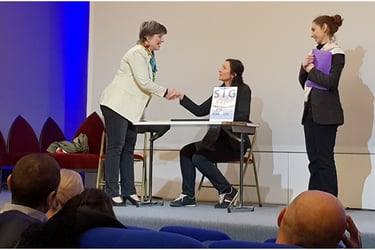 forum accueil de l'usager une femme serre la main d'une autre femme  sous l'oeil d'une autre femme