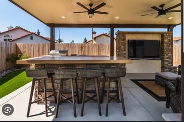 a patio with a bar stool and a ceiling fan