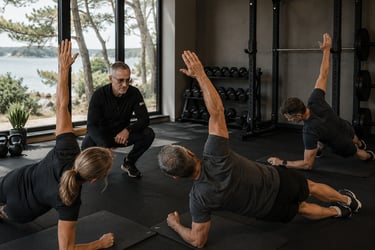 Coach et son small group premium lors d'un exercice de gainage latéral en salle