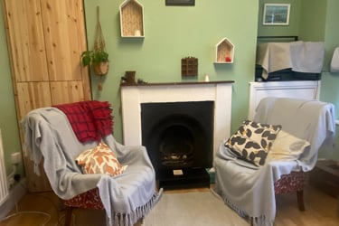 A photo of a  pair of armchairs around a fireplace