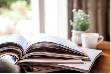Books on a table with coffee mug and plant