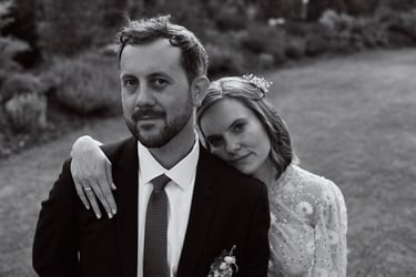Bride standing behind groom leaning on his shoulder.