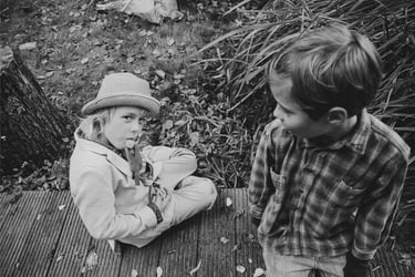 Kids sitting on a wooden pier.
