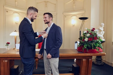 Der Bräutigam legt eine Hochzeitskette mit einem Band um den Hals seines Mannes.