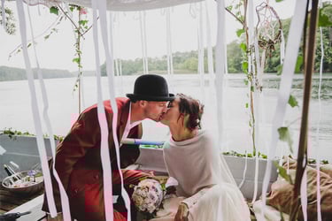 Braut und Bräutigam küssen sich auf einem Boot.