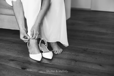 Close up of bride tying shoe strap.