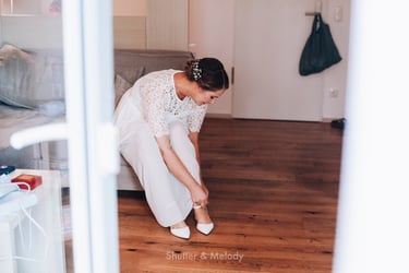 Bride tying up her shoe strap.