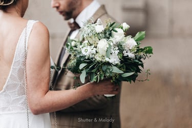 Bridal bouquet with white flowers held by the bride.