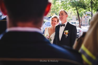Bride and groom listening to a speech outdoors.