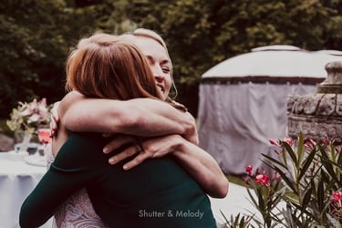 Bride hugging female wedding guest.