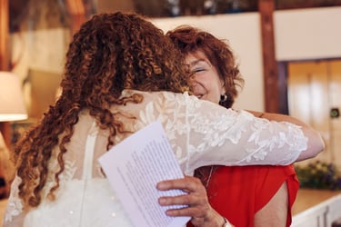 Mother of the groom hugging bride.