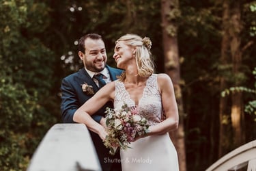 Bride and groom on a bridge laughing.