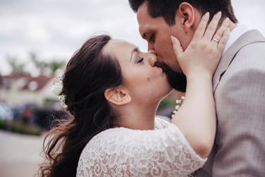 Bride kissing husband while holding his face.