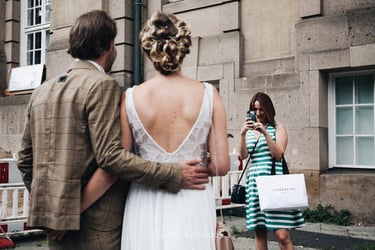 Maid of honor taking a photograph of the bride and groom.