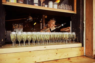Der Barkeeper schenkt Champagner in Gläser ein.
